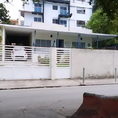 a white fence in front of a white building at Habitacion cerca de la Playa in Boca Chica