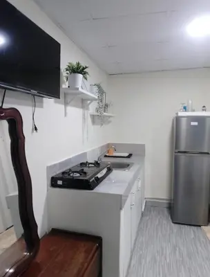 a small kitchen with a stove and a refrigerator at Habitacion cerca de la Playa in Boca Chica