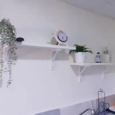 a white shelf with plants and a clock on it at Habitacion cerca de la Playa in Boca Chica
