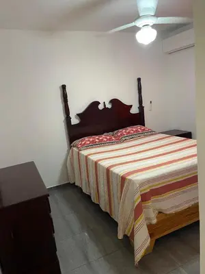 a bedroom with a large bed with a striped blanket at Apartamentos España in Sosúa