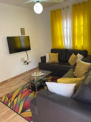 a living room with a couch and a tv at Apartamentos España in Sosúa