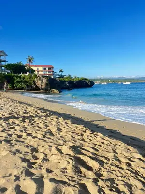 a beach with footprints in the sand and the ocean at Apartamentos España in Sosúa