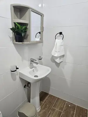 a white bathroom with a sink and a mirror at Eastern Breeze in Hainamosa