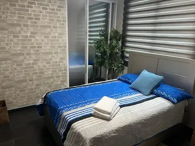 a bed with blue and white blankets and pillows at Dreamvillage in Boca Chica