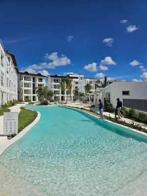 a large swimming pool with two people standing in the water at Garden Breeze Penthouse & Pool View l Ghibli 401 in La Laguna
