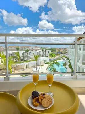a table with two glasses of orange juice and cookies at Garden Breeze Penthouse & Pool View l Mistral 401 in La Laguna