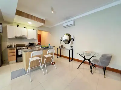 a kitchen with a counter and a table and chairs at Acogedor apartamento ÁGORA MALL in Colorado