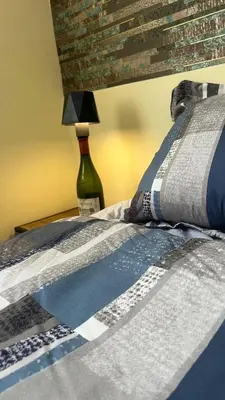 a bed with a blue and white quilt and a lamp at Olas del caribe DR in Santo Domingo