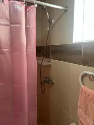 a shower with a pink shower curtain in a bathroom at Olas del caribe DR in Santo Domingo