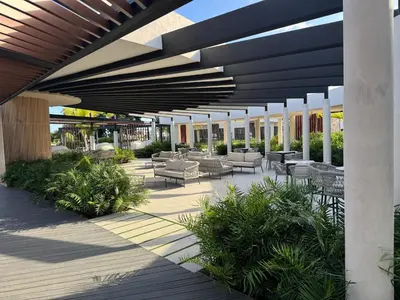 a patio with couches and tables and chairs under a building at Hermoso PUNTA CANA VISTA CANA in Colorado