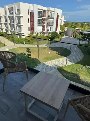 a table and chairs on a balcony with a view of a building at Hermoso PUNTA CANA VISTA CANA in Colorado