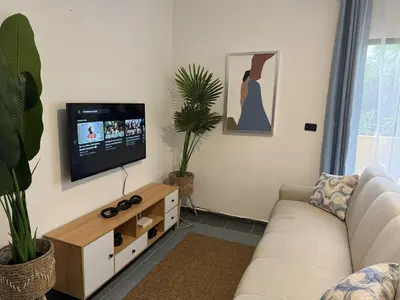 a living room with a couch and a flat screen tv at Costa Lunga-Tropicasa in Boca Chica