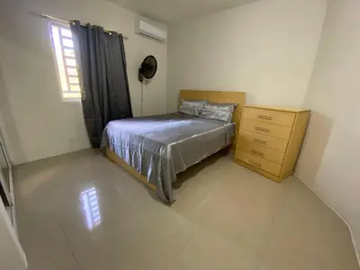 a bedroom with a bed and a dresser and a window at Casa veraniega en samana in Santa Bárbara de Samaná