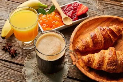 a table with a glass of orange juice and a plate of croissants at Aparta Hotel Azzurra in Boca Chica