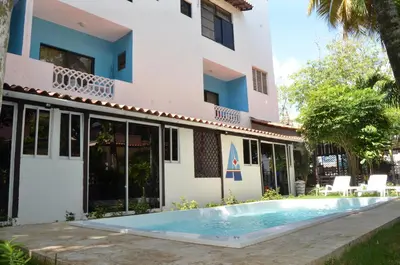 a villa with a swimming pool in front of a building at Aparta Hotel Azzurra in Boca Chica