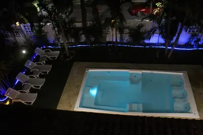 a swimming pool with chairs and a table and sidx sidx at Aparta Hotel Azzurra in Boca Chica