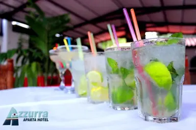 a row of glasses of drinks on a table at Aparta Hotel Azzurra in Boca Chica