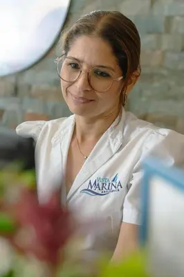 a woman wearing glasses sitting at a table at Vista Marina Residence in Boca Chica