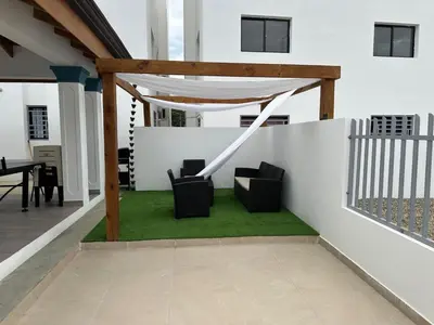 a patio with two chairs and a gazebo at Residencial HH in Santiago de los Caballeros