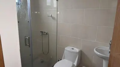 a bathroom with a shower and a toilet and a sink at Residencial HH in Santiago de los Caballeros