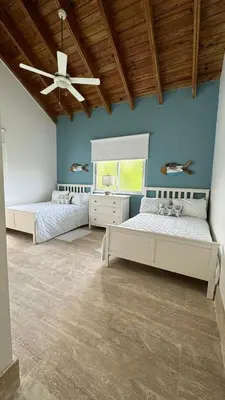 a bedroom with two beds and a ceiling fan at Portillo Beach Family House in El Limón