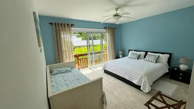 a blue bedroom with a bed and a balcony at Portillo Beach Family House in El Limón
