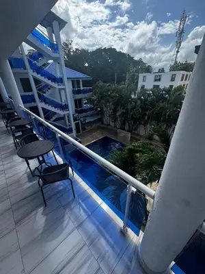 a balcony with chairs and a swimming pool on a building at El Legendario in Sosúa