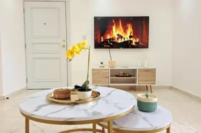 a living room with a table and a fireplace at Stylish 3BR Condo, Full AC, Wi-Fi in Santo Domingo