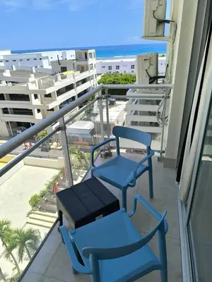 two blue chairs on a balcony with a view of the ocean at Boca del Mar III Apartment 724 in Boca Chica