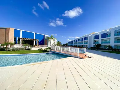 a swimming pool in front of a building at Vista Family Garden Suite Pool front 2 Bdrms in Punta Cana