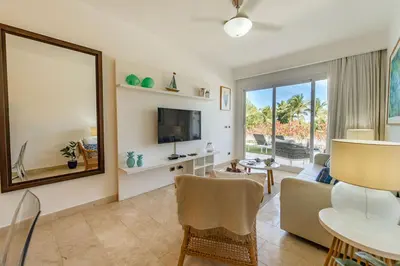 a living room with a large mirror and a couch at Vista Family Garden Suite Pool front 2 Bdrms in Punta Cana
