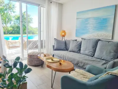 a living room with a couch and a table at Aqua Pearl ! Pool Access 2 BRM J 102 in Punta Cana