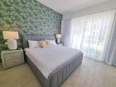 a bedroom with a bed and a large window at Aqua Pearl ! Pool Access 2 BRM J 102 in Punta Cana