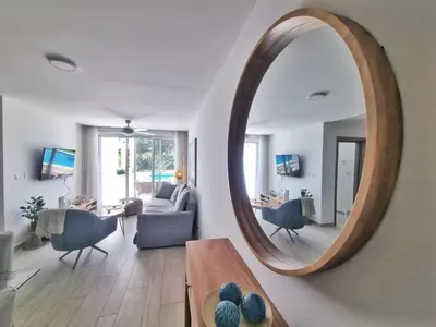 a living room with a large mirror on the wall at Aqua Pearl ! Pool Access 2 BRM J 102 in Punta Cana