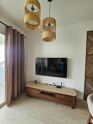 a living room with a television and two hanging baskets at Estrella Garden Condos Dominicus l Meridiana 204 in La Laguna