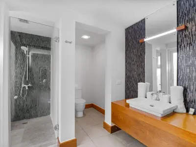 a bathroom with a white sink and a shower at Stay at Ultravioleta Cabarete Beachfront Apartments by EvoKey in Cabarete