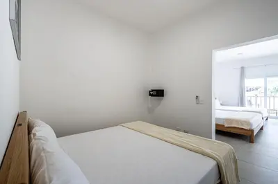 a white room with a bed and a bedroom at Laguna Park Apartments in Sosúa