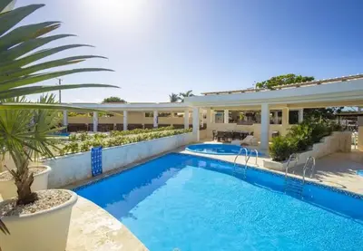 a swimming pool in front of a house at Laguna Park Apartments in Sosúa