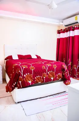 a bedroom with a bed with a red comforter at Apartamento en el malecón cerca de la playa in San Felipe de Puerto Plata