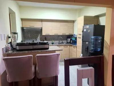 a kitchen with a counter with chairs and a refrigerator at Apartment5Start in Santo Domingo