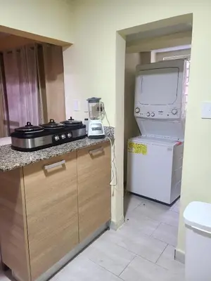 a kitchen with a counter with a stove and a refrigerator at Apartment5Start in Santo Domingo