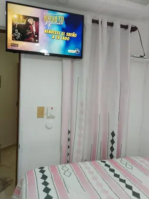a bedroom with a tv on the wall and a bed at Apartaestudio en el malecón y cerca de playas in San Felipe de Puerto Plata