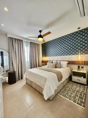 a bedroom with a large bed and a blue wall at Luxury Beachside Retreat & Private Plunge Pool in Punta Cana