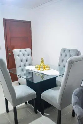 a dining room with a glass table and two chairs at Tu rincon Caribeño in San Isidro