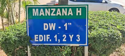a green and blue street sign in front of a bush at Tu rincon Caribeño in San Isidro