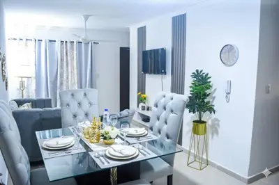 a dining room with a glass table and blue chairs at Tu rincon Caribeño in San Isidro
