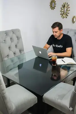 a man sitting at a table with a laptop at Tu rincon Caribeño in San Isidro