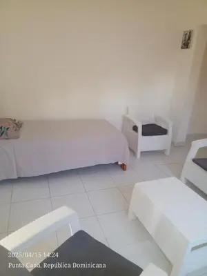 a white room with two beds and a table at Hogar cerca de la playa in Punta Cana