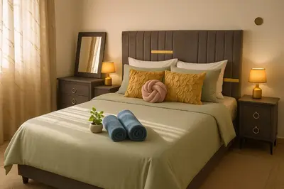 a bedroom with a bed with two blue towels and two lamps at Relaxing and Serene Guest Room in Cancino