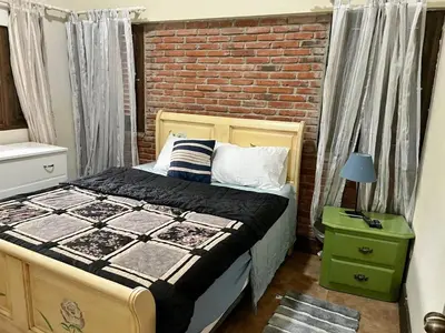 a bedroom with a bed and a brick wall at Teonil in Jarabacoa